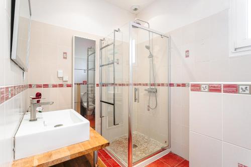 a bathroom with a sink and a shower at Maison Boyardville Piscine Chauffée in Saint-Georges-dʼOléron