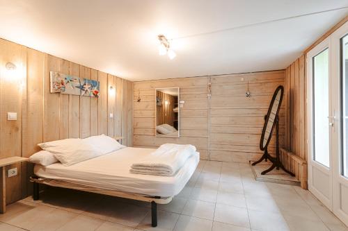 a room with a bed in a room with wooden walls at Maison Boyardville Piscine Chauffée in Saint-Georges-dʼOléron