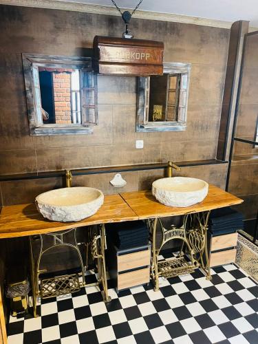 two sinks on a wooden table with a checkered floor at Buri`s Seenlandhaus in Hoyerswerda