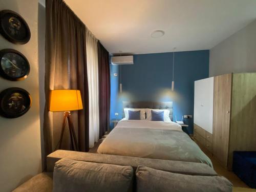 1 dormitorio con 1 cama grande y pared azul en DM Apartments, en Tirana