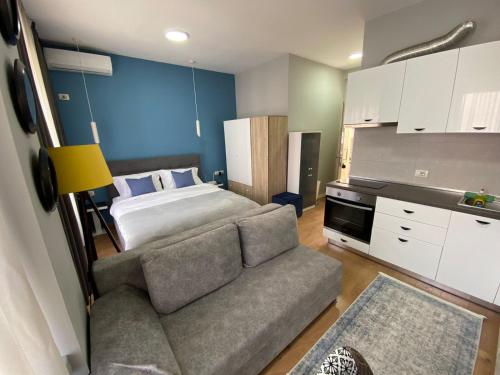 1 dormitorio pequeño con 1 cama y 1 sofá en DM Apartments, en Tirana