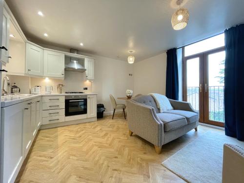 a kitchen with a couch and a chair in a room at Chic Haven in Barnsley in Barnsley