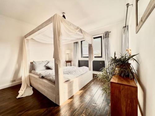 een slaapkamer met een hemelbed bij Designer home on a hill with magical views of London, 5br in Belvedere