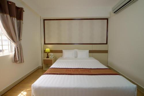 a bedroom with a large white bed with a window at Palago mc Hotel Park View in Ho Chi Minh City