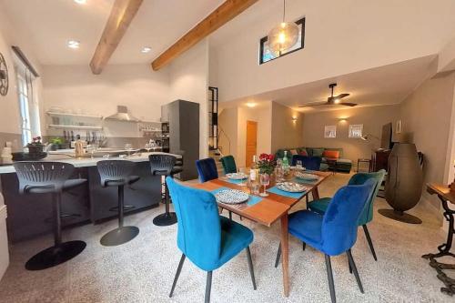 une salle à manger avec une table et des chaises bleues dans l'établissement Maison Mazuc- Central Townhouse Pezenas with Terrace, à Pézenas