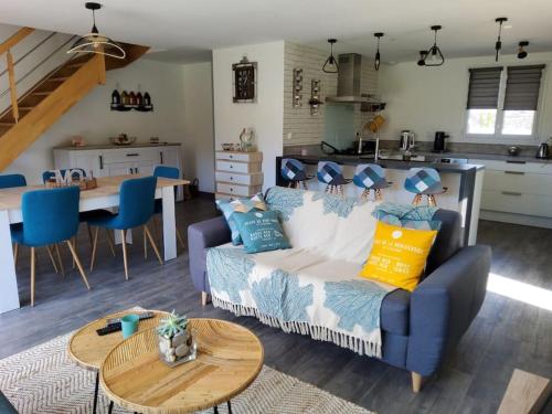 a living room with a couch and a table at 003 QUIN - Maison du Maine in Grand-Village-Plage