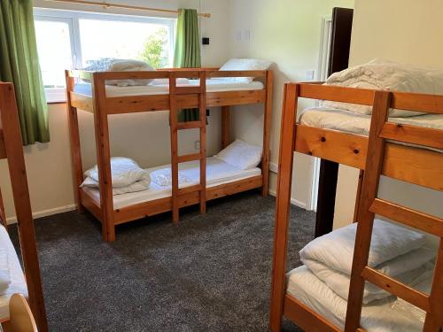 a room with three bunk beds and a window at Newgale Lodge in Newgale