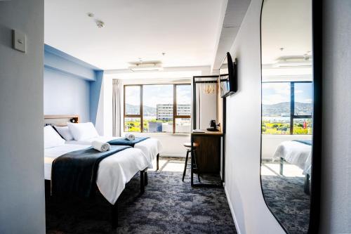 a hotel room with two beds and a window at Haka House Wellington in Wellington