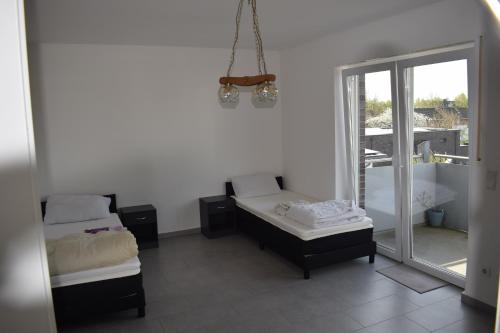 Cette chambre blanche dispose de deux lits et d'une fenêtre. dans l'établissement Apartment in 48599 Gronau Monteurzimmer 2, à Gronau