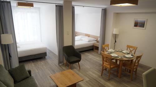吉日茨科的住宿－Aparthotel Passage，一间带桌子的客厅和一间卧室