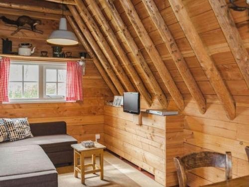 ein Wohnzimmer mit einem Sofa und einem TV in einer Hütte in der Unterkunft Nice holiday home in Ruinerwold with garden in Ruinerwold
