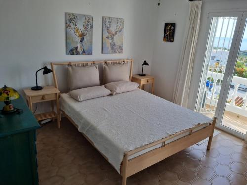 1 dormitorio con 1 cama con 2 mesas y una ventana en JARDINES DE NERJA 18 MENYBER, en Nerja