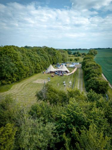 uma vista sobre um campo com uma tenda e árvores em Glamping at Beaumont Paddocks em Saint Albans