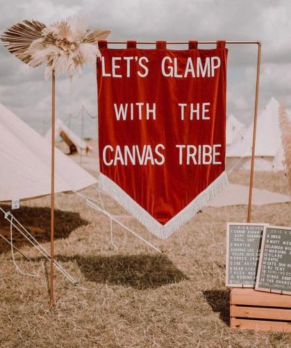a red sign that says lets clamp with the canvas tribe at Glamping at Beaumont Paddocks in St. Albans
