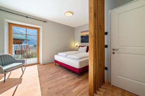a bedroom with a bed and a window at Villa Rosa Unterschöberlehof - Lene in Merano