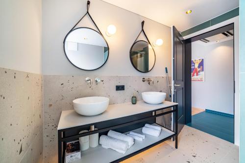 a bathroom with two sinks and two mirrors at Villa Rosa Unterschöberlehof - Lene in Merano