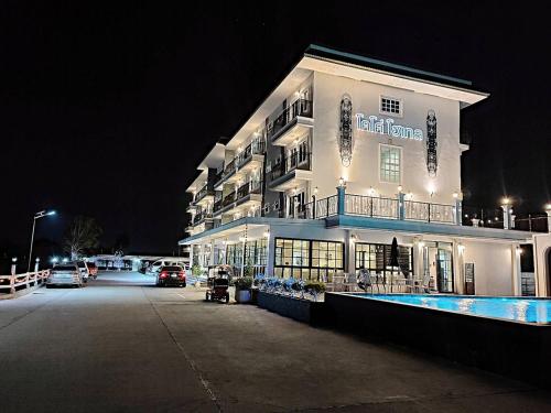 a large building with a pool in front of it at night at โคโค่ โฮเทล KOCO Hotel in Nakhon Ratchasima