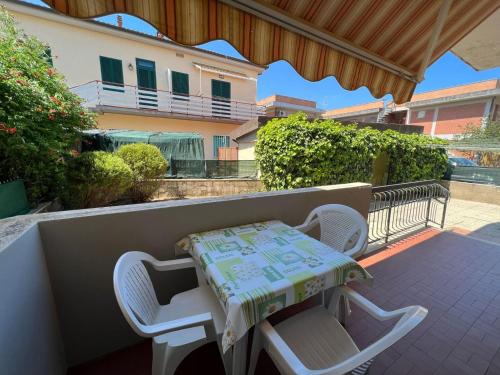 einen Tisch und zwei Stühle auf einem Balkon mit einem Tisch in der Unterkunft Appartamenti NA in Follonica
