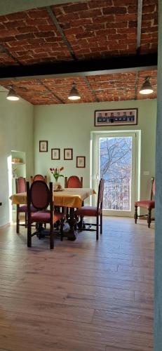 a dining room with a table and chairs and a window at Villa Aurora in Torre Pellice