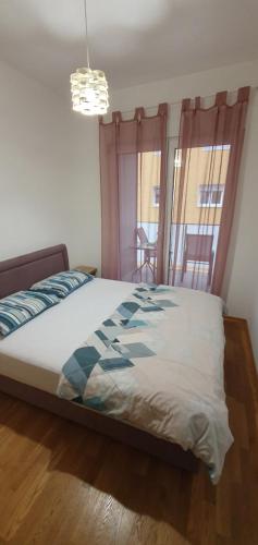 - une chambre avec un lit et un lustre dans l'établissement Odmor u Podgorici., à Podgorica