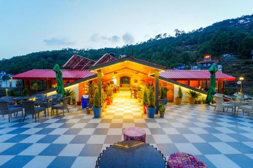 Ein Resort mit einem karierten Boden sowie Tischen und Stühlen in der Unterkunft Hotel Rawat in Ludhiana