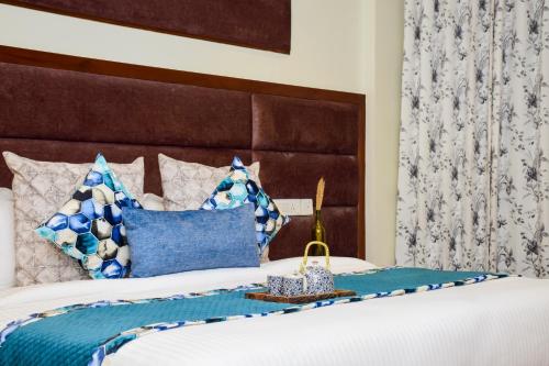 a bedroom with a bed with blue and white pillows at Hotel Rawat in Ludhiana