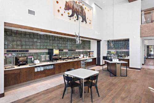 un restaurant avec une table, des chaises et un comptoir dans l'établissement Home2 Suites By Hilton Big Bear Lake, à Big Bear Lake