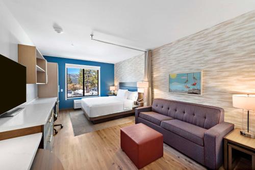 uma sala de estar com um sofá e uma cama em Home2 Suites By Hilton Big Bear Lake em Big Bear Lake