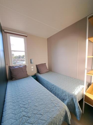 a bedroom with two beds and a window at Chalet n * 1 au cœur du maquis in Bonifacio