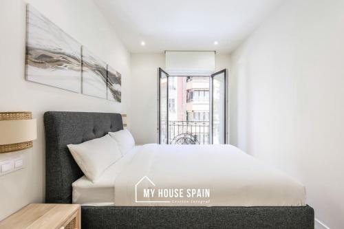 een slaapkamer met een bed en een raam bij MyHouseSpain - Renovado y luminoso apartamento in Madrid