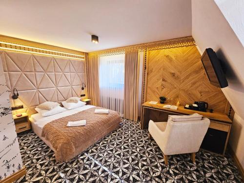 a bedroom with a bed and a desk and a chair at Willa Regina I Resort & SPA in Zakopane