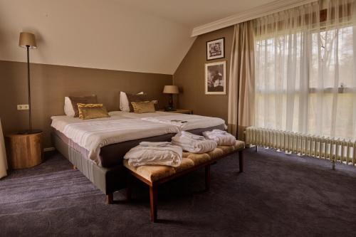 a bedroom with a large bed and a window at Landgoed De Holtweijde in Lattrop