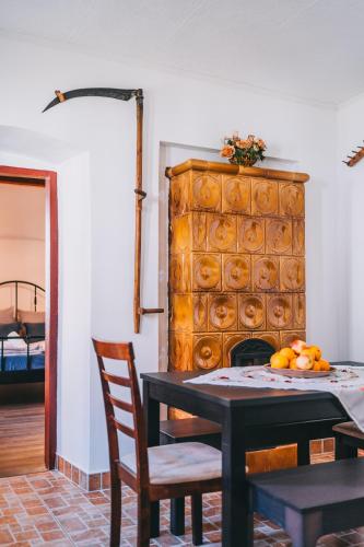 a dining room with a table and a fireplace at Feher Barany Apartment in Szigliget
