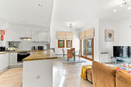 a kitchen and living room with a couch and a table at 2 bedroom Villa Loukia with private pool and gardens, Aphrodite Hills Resort in Kouklia