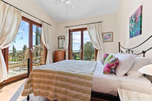 um quarto com uma cama e uma grande janela em 2 bedroom Villa Loukia with private pool and gardens, Aphrodite Hills Resort em Kouklia