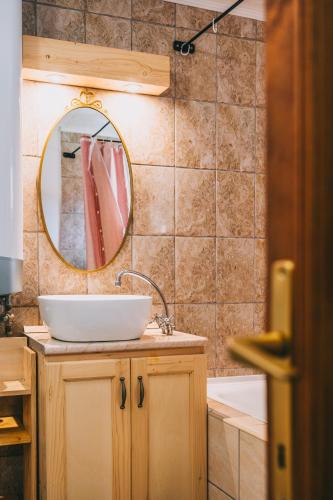 a bathroom with a sink and a mirror and a tub at Feher Barany Apartment in Szigliget