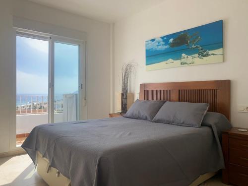 a bedroom with a bed and a large window at RESIDENCIAL OASIS 5 in Mojácar