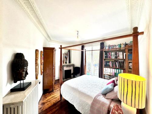 une chambre avec un lit et une étagère dans l'établissement Paris 2 bedrooms chic apartment 18th district, à Paris