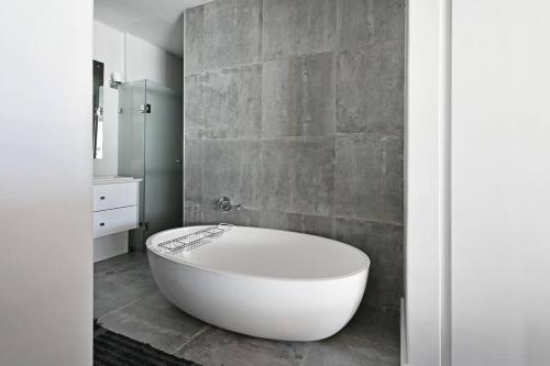 uma casa de banho com uma grande banheira branca num quarto em Bella 703 - De Oude Schuur em Cidade do Cabo