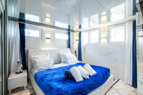 a bedroom with a blue bed with white pillows at Appartement tout confort - Paris à 10 min - tout équipé - salle de jeux in Deuil-la-Barre