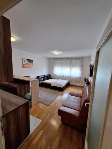 a living room with a couch and a bed at Apartman Sarah - Autobuska Stanica in Tuzla