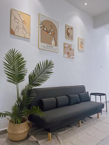 a living room with a blue couch and a plant at Elonna Homestay in Jerantut