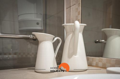 two white vases sitting on a counter in a bathroom at #093 Kid Friendly Ocean View with AC, Pool in Albufeira