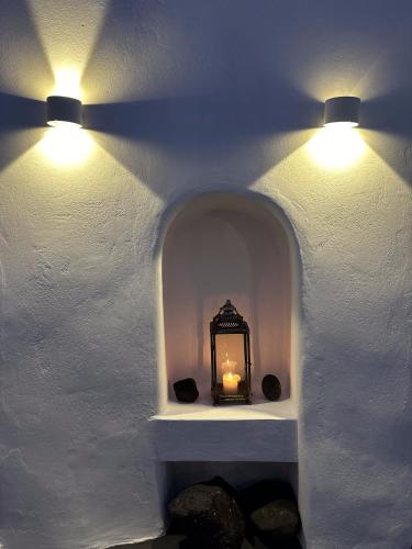 two lights on a white wall with a lantern at Argy's Luxury Caves in Megalokhori