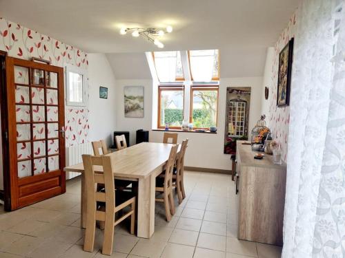 une cuisine et une salle à manger avec une table et des chaises en bois dans l'établissement Villa Ludi, à Portbail