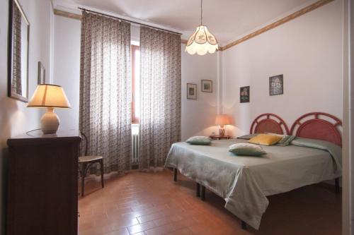 a bedroom with two beds and a table with a lamp at Appartamento TL in Follonica