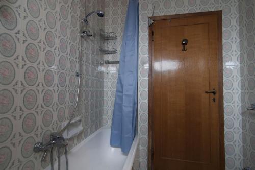 La salle de bains est pourvue d'une douche et d'une porte en bois. dans l'établissement Appartamento TL, à Follonica