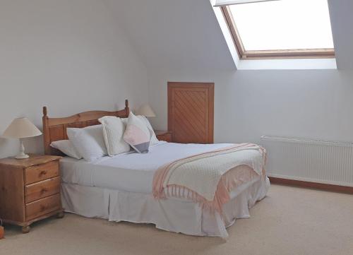 a bedroom with a bed and a skylight at El Martins in Miltown Malbay