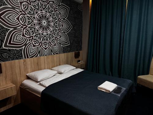 a bedroom with a bed with two towels on it at Altyn Shatyr Hotel and Restaurant in Aksay