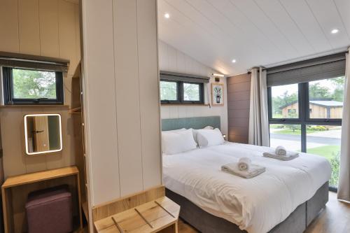 a bedroom with a large bed and a tv at Blenheim Palace Lodge Retreat in Woodstock